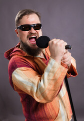 Bearded emotional rock singer with microphone studio portrait.