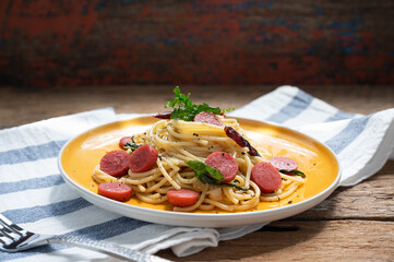 Spaghetti spicy with sausage in yellow dish