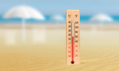 Sea coast at hot summer day. Thermometer in the sand shows plus 18 degrees celsius