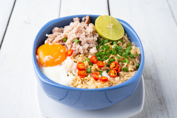 Instant noodles with minced pork and egg in bowl.