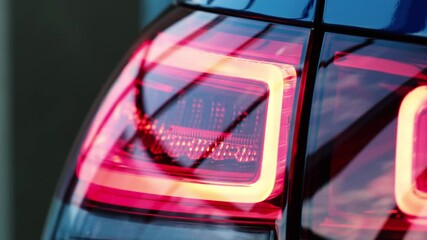 Close up of rear Red LED Brake Light New Luxury Car in Sales Showroom