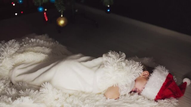a child in red clothes is sitting waiting for the new year. the concept of celebrating Christmas at midnight. holiday costume