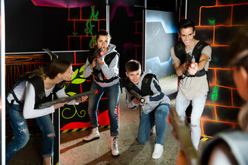 Group of young people playing laser tag game with laser guns. High quality photo