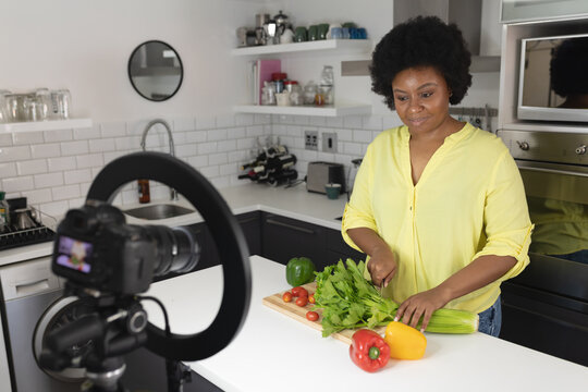 African american female vlogger recording a video in kitchen