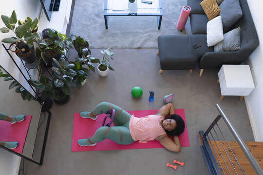 Overhead view of african american woman lying on exercise mat working out - Powered by Adobe