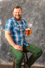 Matured smiling bearded man in shirt with beer mug