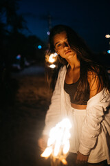 Young woman with torchlight on the beach at night