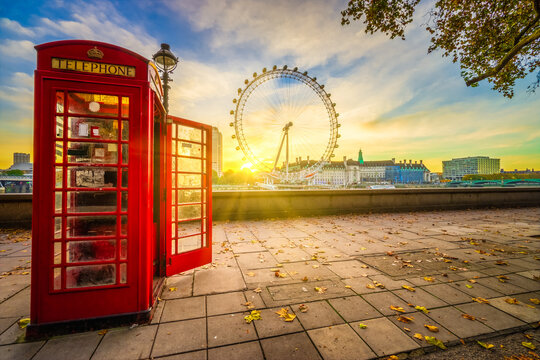 London,England-October 2015: Red telephone booth and Coca Cola wheel known as London eye at sunrise during autumn season