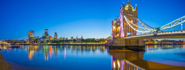 Panorama of Tower Bridge and skyscrapers of financial district at dusk