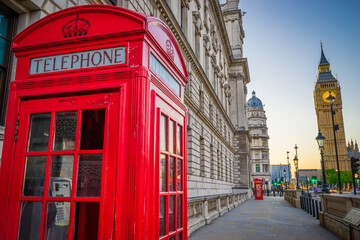 Red telephone both near Big Ben at sunrise. London, Great Britain 