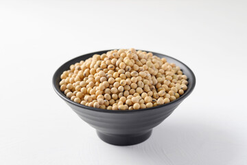 Soybeans seed in a black bowl on white background