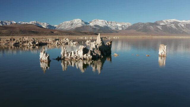 Mono Lake on early morning, 4K. Mountains covered by snow under clear blue sky