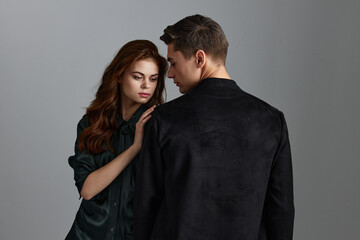 man hugs pretty woman on gray background back view