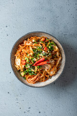 Asian food, wok noodle and vegetables in ceramic bowl, top view