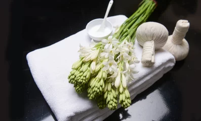 Fotobehang spa concept with bunch of tuberose flowers ,buds,spoon, cream in bowl on towel, and herbal, ball,   © Mee Ting