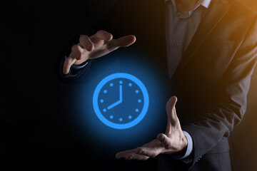 Businessman hand holds the icon of hours clock with arrow. Rapid execution of the work.Business...