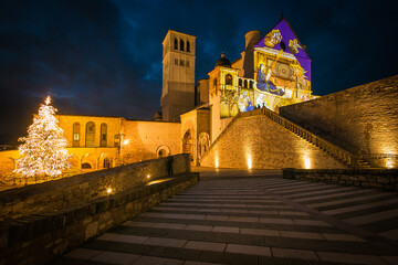 The famous basilica of Saint Francis of Assisi and christmas tree in Umbria at night, Italy