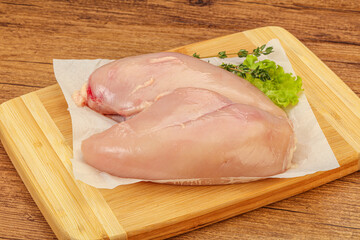 Raw chicken breast over board