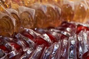 Yellow and red lollipops in wrappers close up