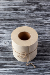 Eco-friendly bamboo toilet paper on black wooden background.