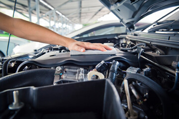 Worker man open the car hood and polishing car with microfiber cloth ,vintage style