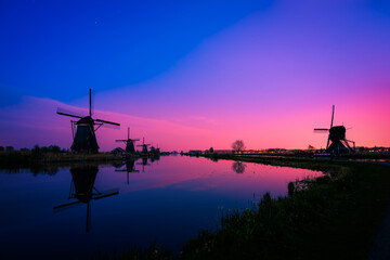 Fototapeta na wymiar Silhouette of traditional Dutch windmills at dusk in Kinderdijk. Netherlands 