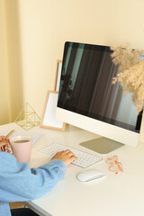 Woman working on modern computer on white table