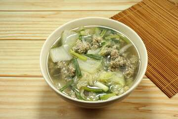 Clear soup of cutting Chinese cabbage mixed with minced pork and fresh spring onion in the bowl. Famous traditional soup menu in Asia restaurant.