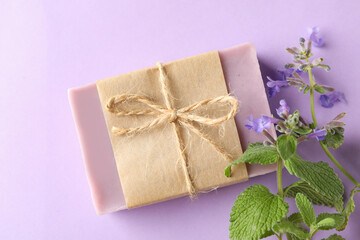 Fototapeta na wymiar Piece of natural soap on violet background