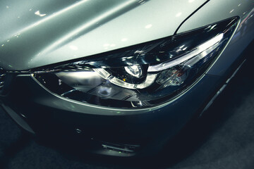 Obraz na płótnie Canvas Headlight of a modern luxury car, auto detail,car care concept ,daytime running light