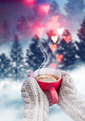 Foggy snowy forest, red cup with tea in female hands on the background of a winter forest. Red hearts bokeh, love.