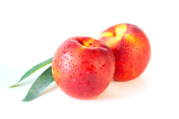 Peach or nectarine and peach slice with leaf on white background