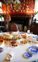 table served with appetizers, plates with a blue pattern and glasses for wine. 