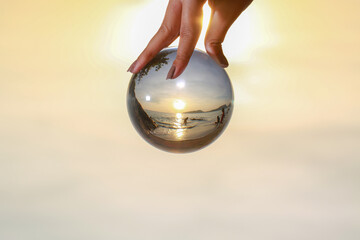 .lady catch the crystal ball on her hand beside Patong beach during sunset