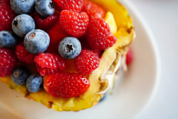 pineapple stuffed with raspberry berries, strawberries, blueberries. 