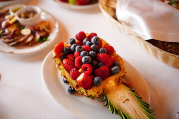 pineapple stuffed with raspberry berries, strawberries, blueberries. 