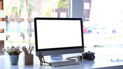 A computer and equipment on white office desk. Blank screen for your information.