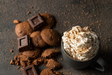 Hot chocolate or cocoa cups with whipped cream , chocolate slices and cookies on concrete background. Traditional beverage for cold days concept. Copy space