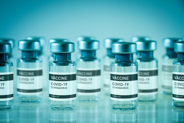 Covid-19 vaccine bottles on a blue background