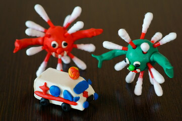 Toy car ambulance and the figure of the virus on the table.