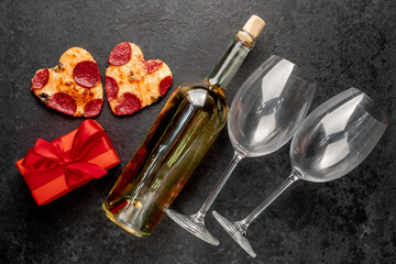 Dinner for two. Two heart-shaped pepperoni pizzas and a bottle of white wine, glasses, Valentine's...