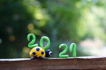 Figure 2021. Next to it is a figurine of a ladybug made of plasticine. The number 20 is located on the figure.