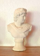 Obraz premium Simple statue on a wooden table, mass manufactured