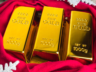 Gold bars as christmas present on wooden table with ornaments.