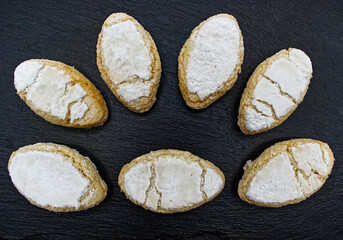 Obraz na płótnie Canvas Ricciarelli, almond cookies originating from Siena, Tuscany, Italy. Ricciarelli senesi are traditional Christmas marzipan cookies, made with almonds, sugar, egg whites. 
