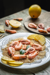 Appetizing delicious frozen dish of shrimps and rice with lemon on a wooden table. Concept of ready made frozen food for dinner like in a restaurant at home