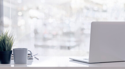 Mockup laptop computer on white top table with blur background.