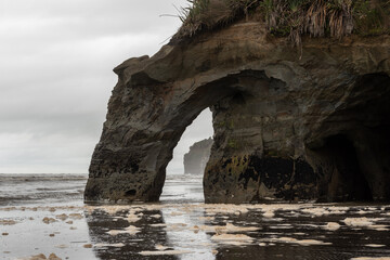 Natural arch near the Three Sisters rock stacks on the beach at Tongaporutu, Taranaki, New Zealand.