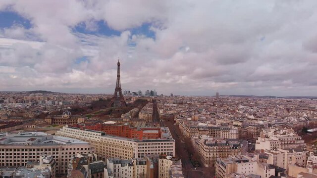 Central Paris aerial footage. Early spring, 7th arrondissement Paris buildings, &Eacute;cole Militaire, Champ de Mars and Eiffel Tower against blue sky with white clouds