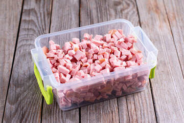 Chopped sausage in a container. Storage of prepared foods in plastic container.